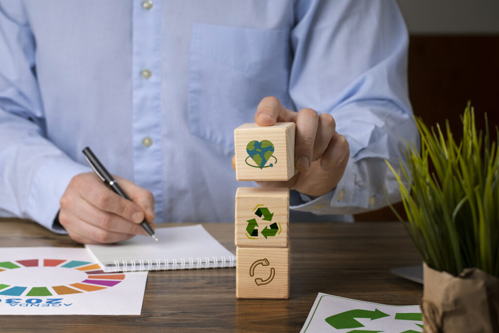 Homem empilhando blocos de madeira com símbolos de reciclagem e sustentabilidade, representando o conceito de economia circular no ambiente corporativo.